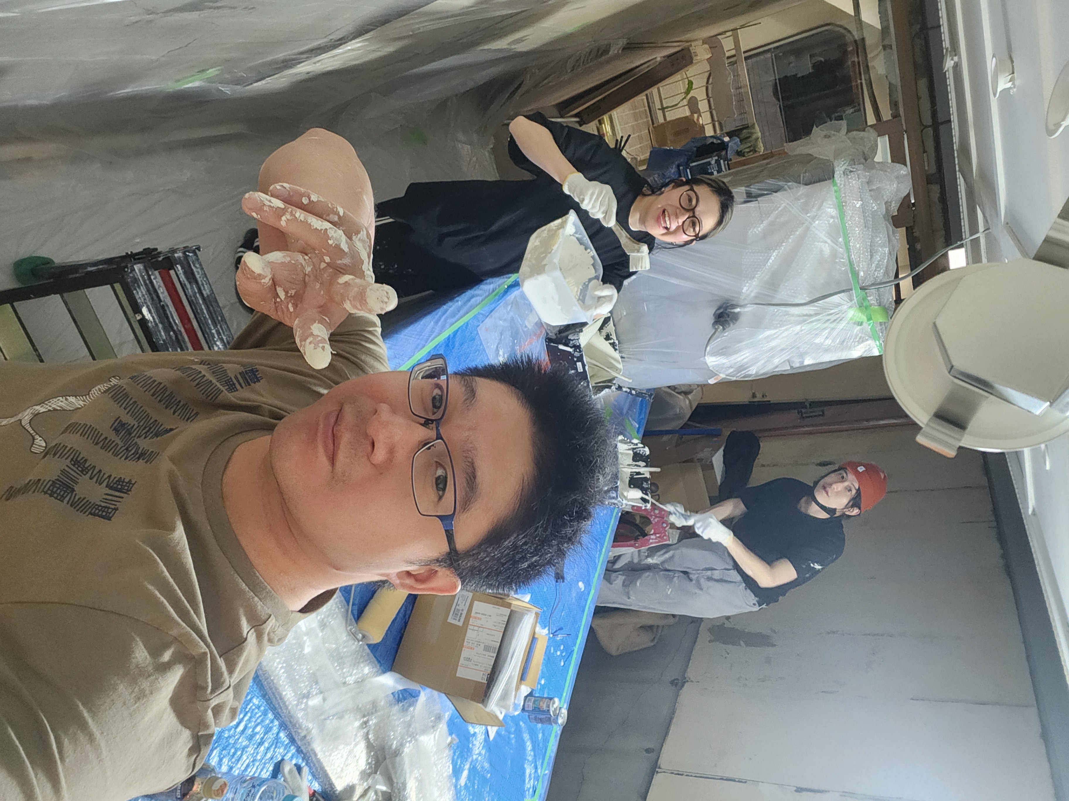 The team mixing plaster and building the space themselves, hands covered in filler