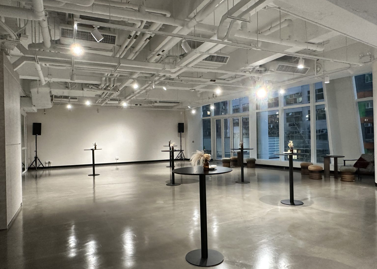 Open modular event space with bar tables and city windows